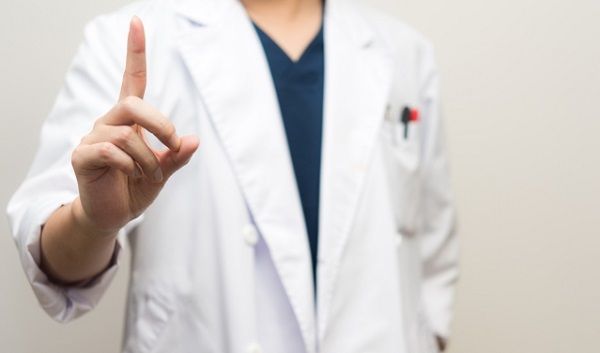 人差し指を立てて病気について説明する医師