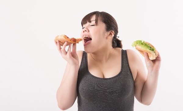 ピザに食らいつくタンクトップのデブ女性